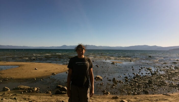 DJ standing in front of a low Lake Tahoe